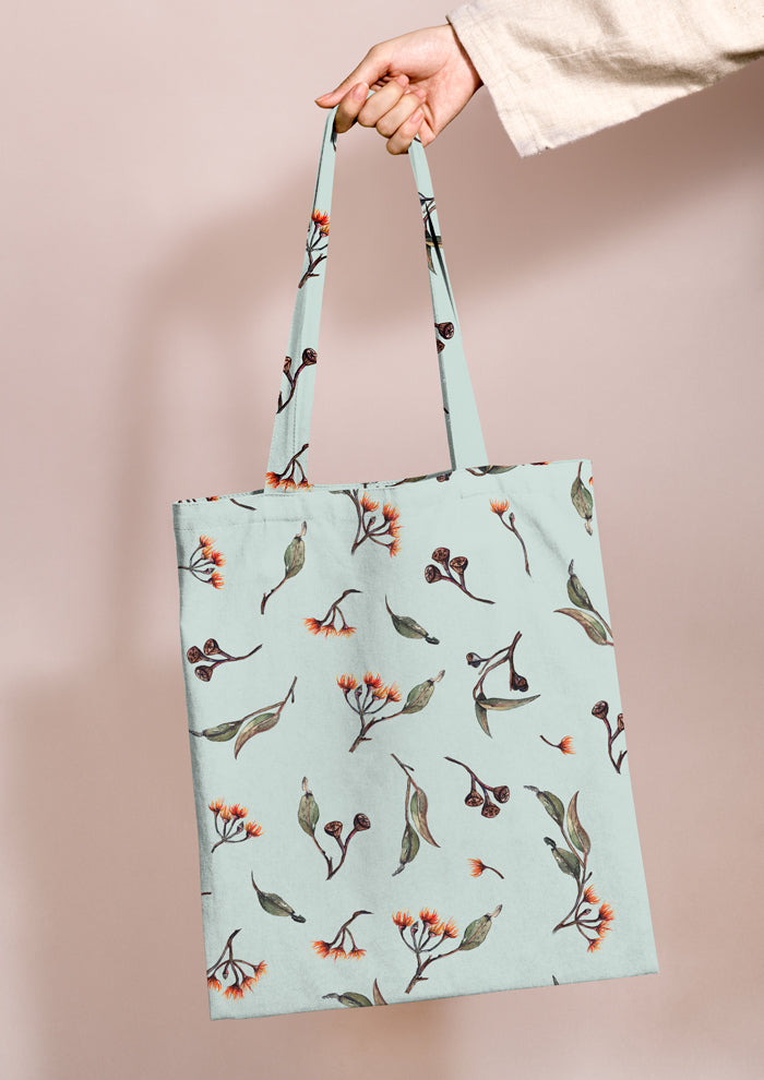 Shopping bag featuring Eucalypt Echo pattern on a mint backgrounf , flowing eucalyptus elements spaced widely for dramatic impact on wallpaper or large fabric prints.