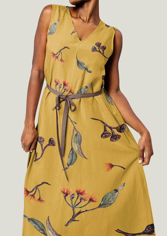 Dress featuring Eucalypt Echo pattern in a mustard palette, flowing eucalyptus elements spaced widely for dramatic impact on wallpaper or large fabric prints.