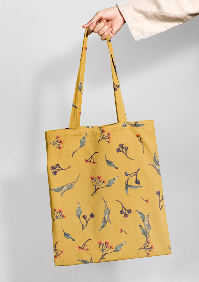 Tote bag featuring Eucalypt Echo pattern in a mustard palette, flowing eucalyptus elements spaced widely for dramatic impact on wallpaper or large fabric prints.