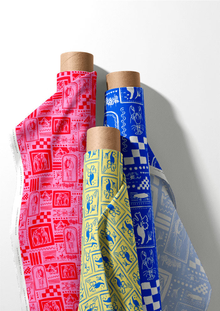 Three rolls of patterned fabric on wooden spools against a white background
