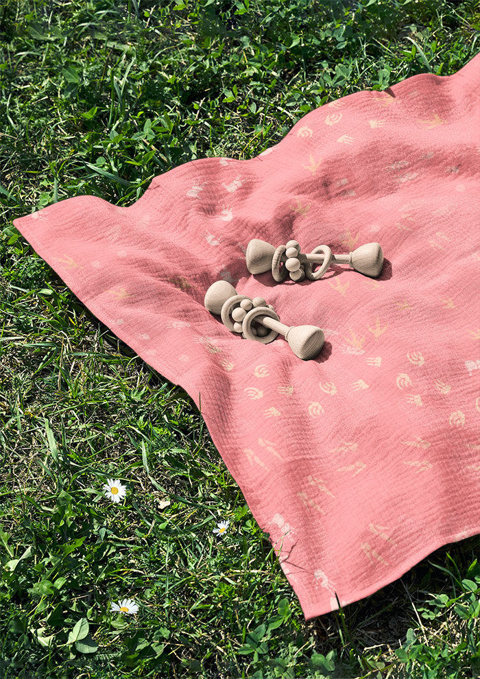 Pink baby muslin featuring whimsical Australian wildlife footprints – kangaroo, echidna, wombat, and more – inspired by bushland trails and nature’s stories. Australian surface pattern design.