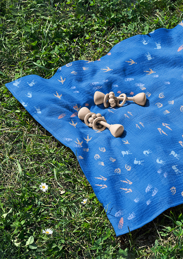 Blue baby swaddle featuring whimsical Australian wildlife footprints – kangaroo, echidna, wombat, and more – inspired by bushland trails and nature’s stories. Australian surface pattern design.