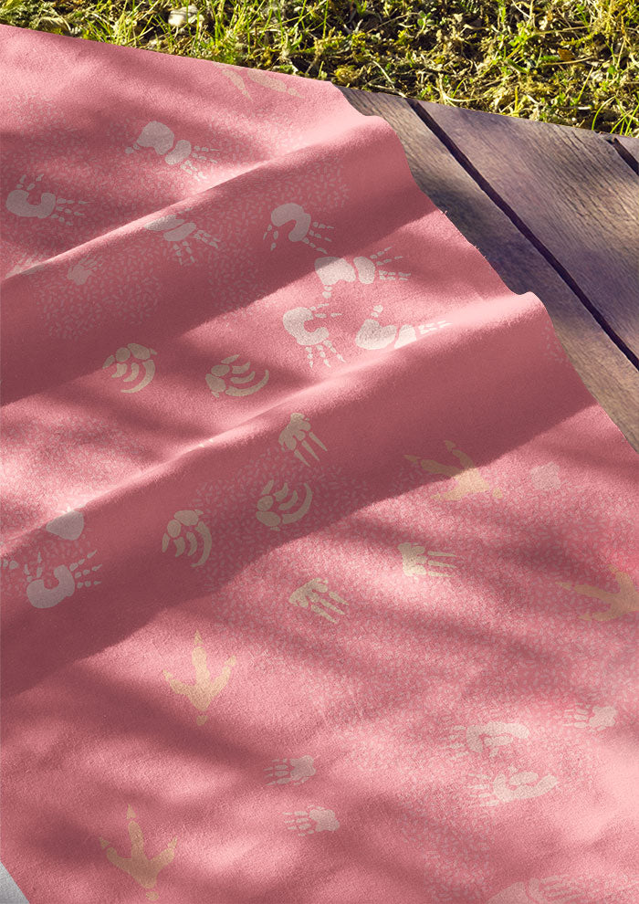 Pink fabric featuring whimsical Australian wildlife footprints – kangaroo, echidna, wombat, and more – inspired by bushland trails and nature’s stories. Australian surface pattern design.