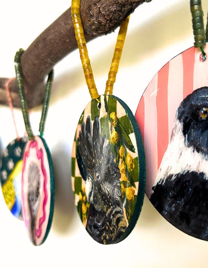 Close-up of Yellowtail black cockatoo ornament showing glossy resin finish and handmade beaded hanger