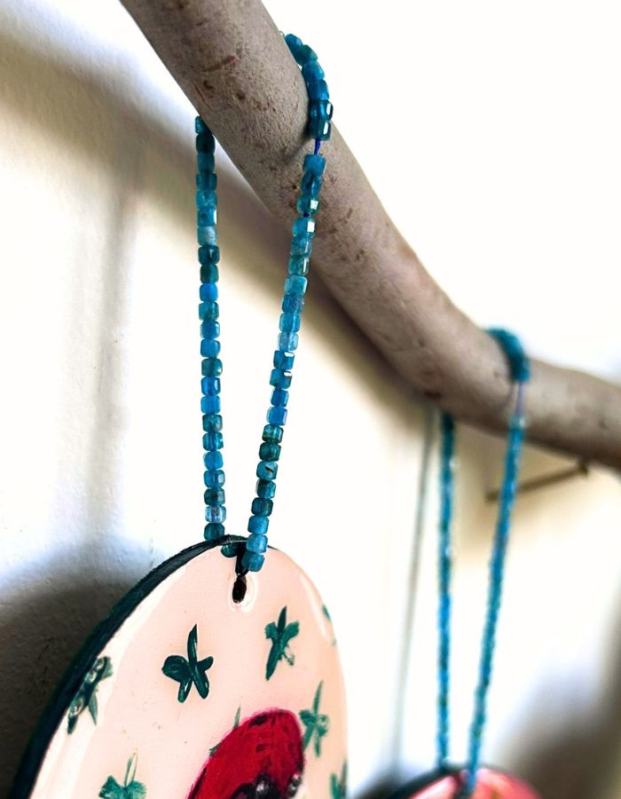 Close-up of Little Red rosella ornament showing glossy resin finish and handmade beaded hanger