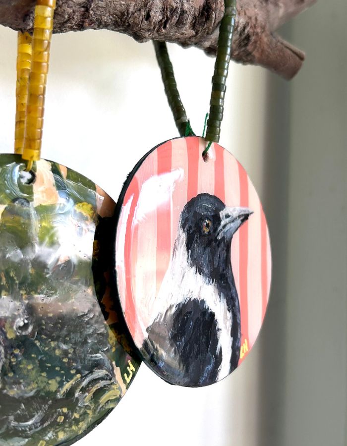 Close-up of Maggie magpie ornament showing glossy resin finish and handmade beaded hanger