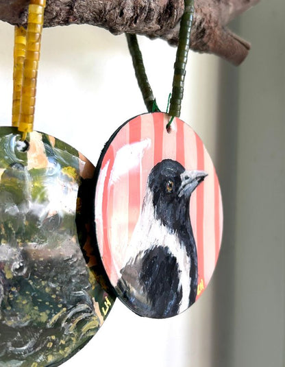Close-up of Maggie magpie ornament showing glossy resin finish and handmade beaded hanger