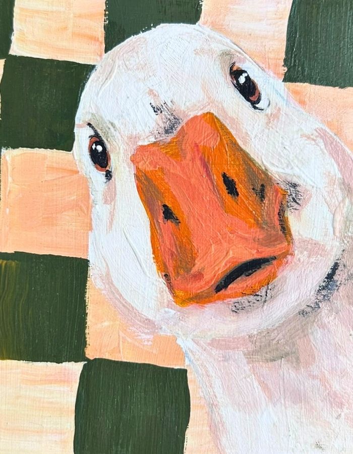 Close-up of white duck with orange beak on green checked background