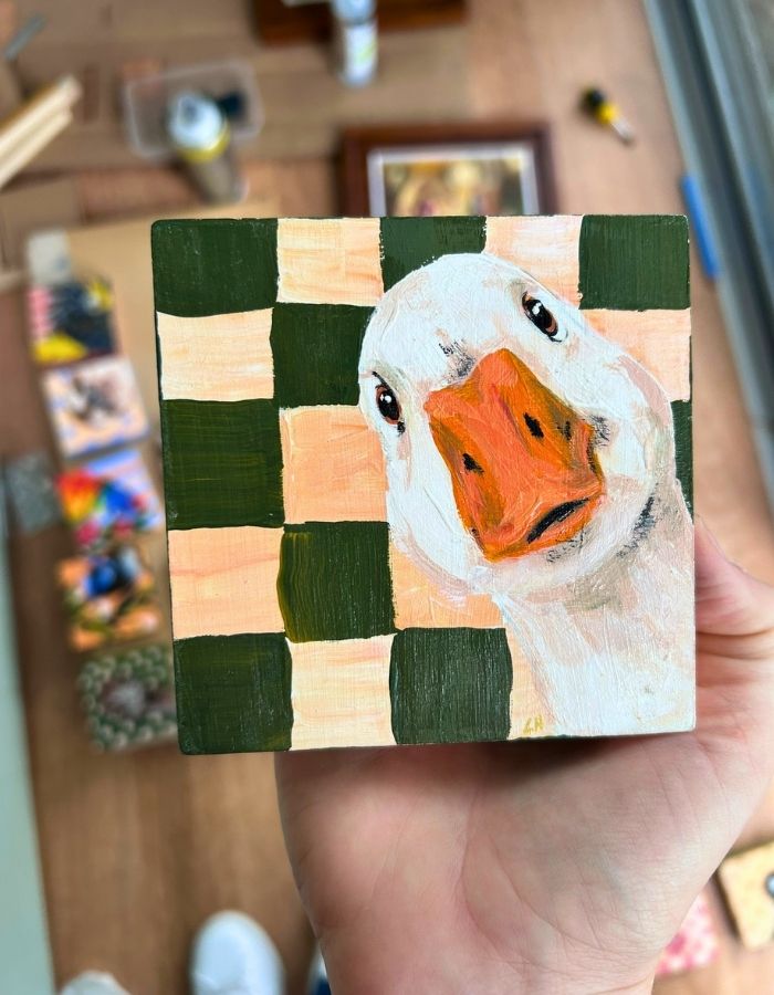 Original duck mini painting held in hand to show scale