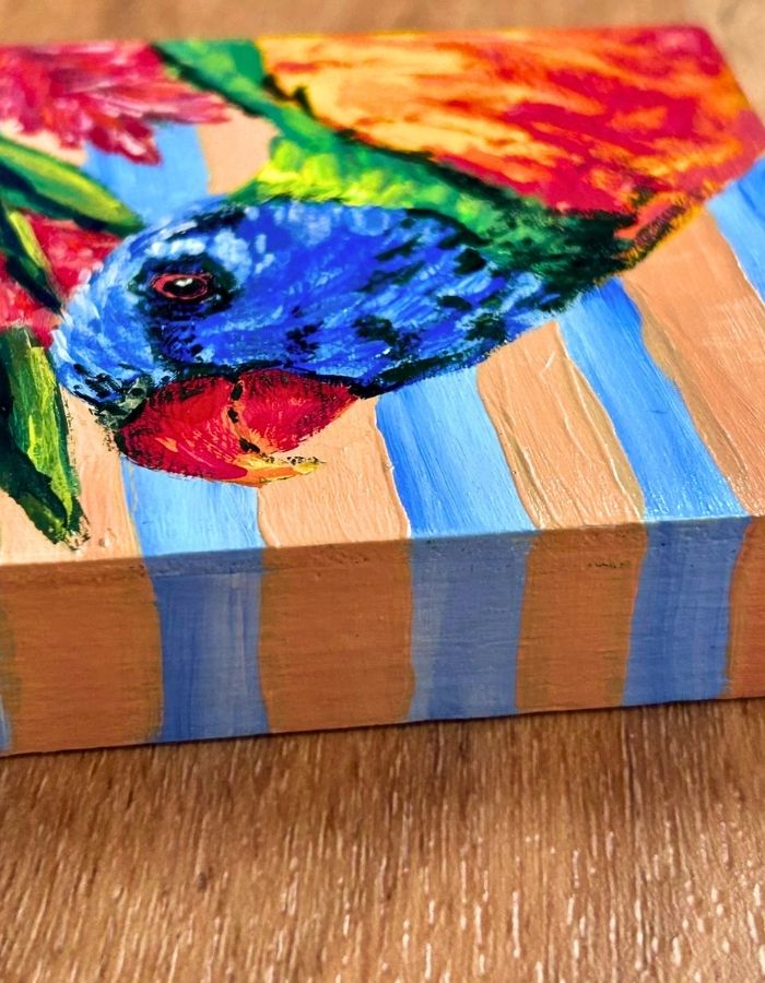 Hand-painted striped edges of rainbow lorikeet timber panel