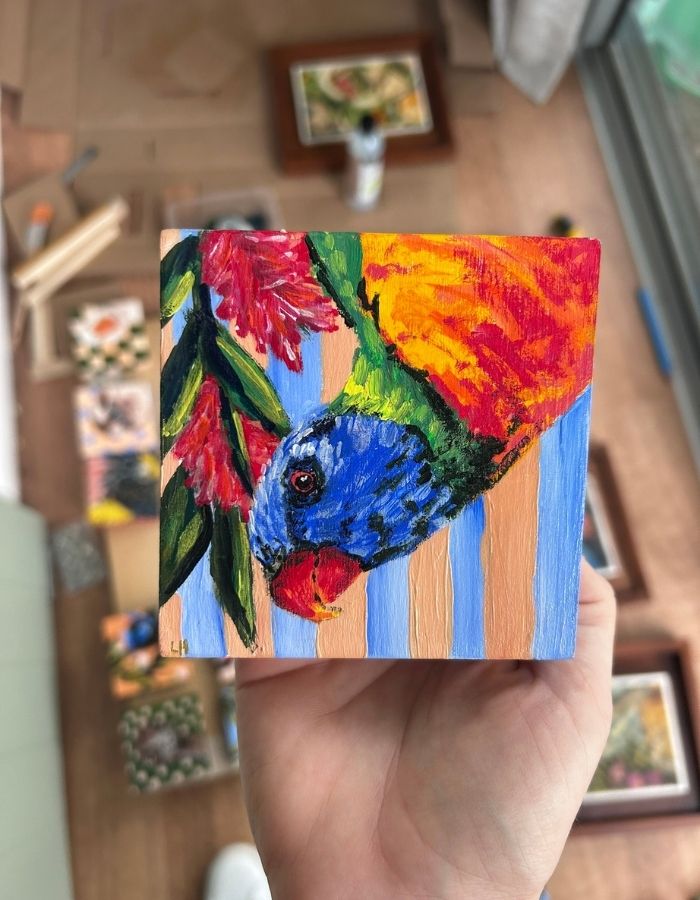 Laurakeet original bird painting held in hand to show scale