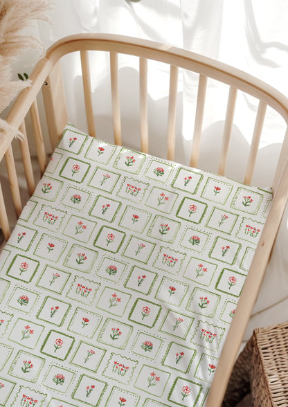 Watercolour botanical cot sheets — Patchwork Garden pattern with playful flowers in frames.