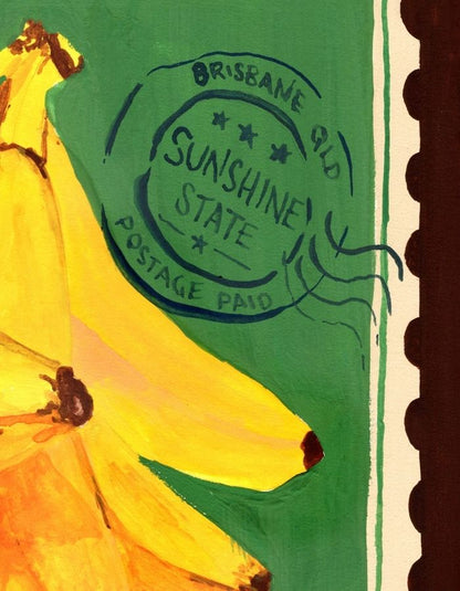 A close-up artwork of a banana on a green background with a postage stamp motif and the words 'Brisbane QLD Sunshine State Postage Paid.' This appears to be the product itself rather than a lifestyle scene, so subject_type is Product/Packaging.