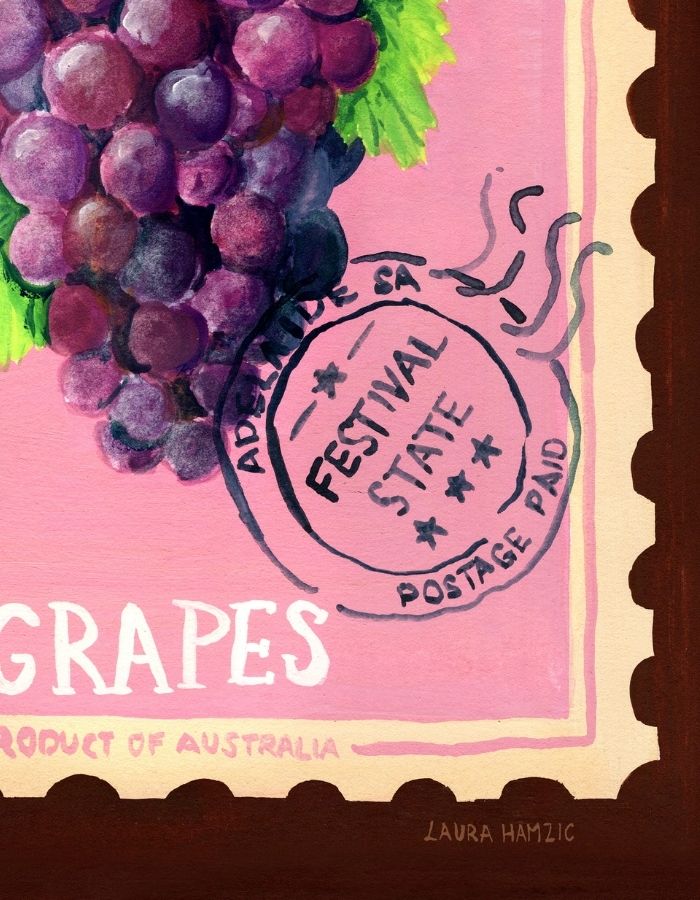 A close-up of a painted artwork featuring a bunch of purple grapes with green leaves on a pink background, with decorative stamp-like markings and the word 'GRAPES' visible. This appears to be the product itself rather than a lifestyle scene, so subject_type is Scenery.