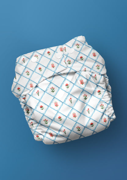 Hand-illustrated floral nappy with quilted floral design in a diamond blanket stitch style pattern — Quilted Blooms pattern, botanical baby wear design.